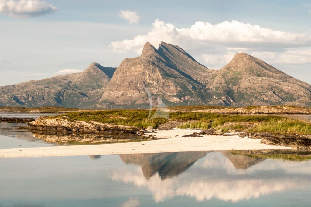 Granite peaks reflected in a calm bay on the Norwegian coast